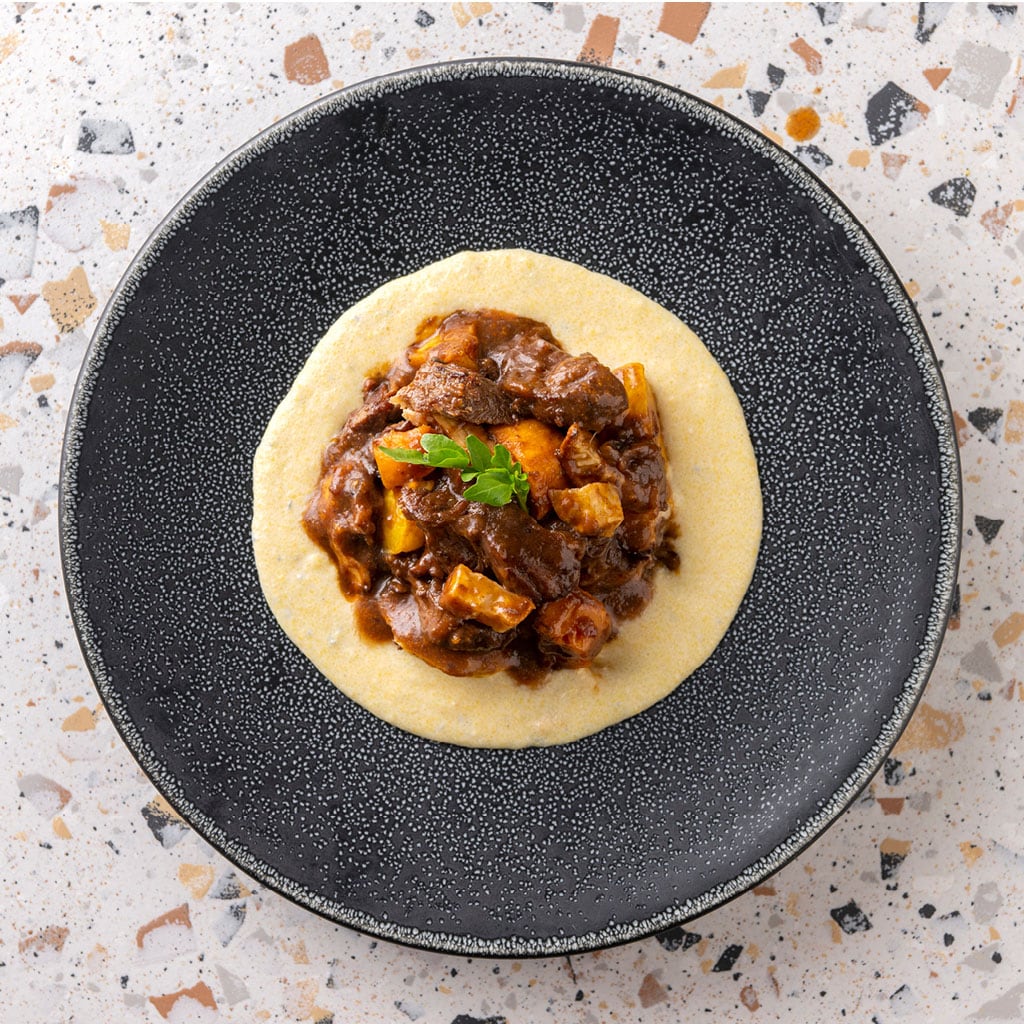 Kalfsblokjes in tomatensaus met wintergroenten en polenta